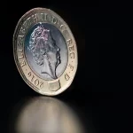 FootballR - NFL - Eine britische Pfund-Münze auf schwarzem Hintergrund.