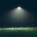 FootballR - NFL - Ein Fußballplatz wurde nachts beleuchtet.