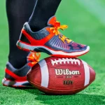 FootballR - NFL - Die Füße einer Person stehen auf einem Fußball.