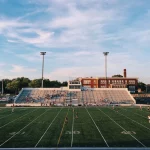 FootballR - NFL - Ein leeres Fußballfeld mit Leuten, die Fußball spielen.