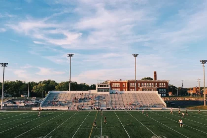FootballR - NFL - Ein leeres Fußballfeld mit Leuten, die Fußball spielen.