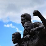 FootballR - NFL - Eine Statue von drei Männern, die ihre Fäuste hochhalten.