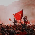 FootballR - NFL - Eine Menschenmenge, die in einer Stadt rote Fahnen schwenkt.