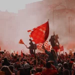 FootballR - NFL - Eine Menschenmenge, die in einer Stadt rote Fahnen schwenkt.