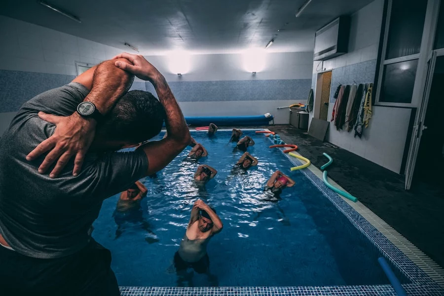 FootballR - NFL - Eine Gruppe von Menschen, die Yoga in einem Schwimmbad praktizieren.
