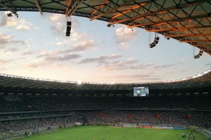 FootballR - NFL - Ein Fußballspiel in einem Stadion bei Sonnenuntergang.