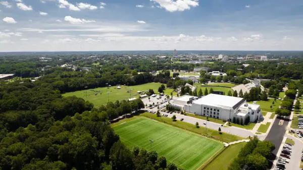 FootballR - NFL - Eine Luftaufnahme eines Campus mit einem Fußballfeld und Bäumen.