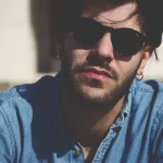 FootballR - NFL - Ein Mann mit Sonnenbrille und Jeanshemd.