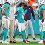 FootballR - NFL - Die Spieler der Miami Dolphins, darunter Tyreek Hill, sind auf dem Spielfeld.