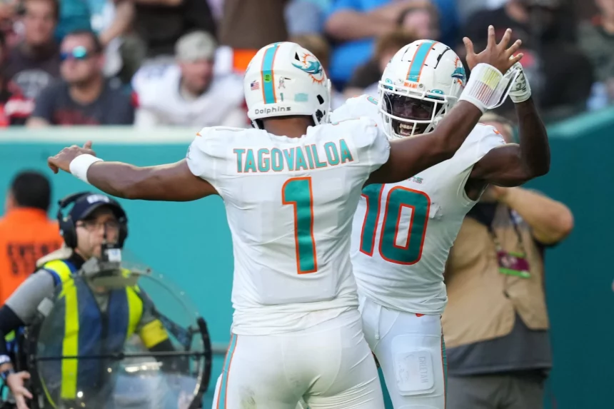 FootballR - NFL - Zwei Spieler der Miami Dolphins, Tyreek Hill und Tua Tagovailoa, feiern während eines Spiels und zeigen damit ihre tolle Zusammenarbeit.