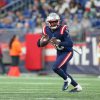 FootballR - NFL - Patriots-Footballspieler, Malik Cunningham, läuft mit dem Ball während eines Quarterback-Wechsels.