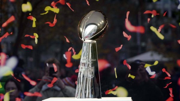 FootballR - NFL - Die Super Bowl-Trophäe wird stolz inmitten eines Konfetti-Meeres präsentiert und symbolisiert die Siegesfeier des Super Bowl 2027 am Austragungsort.
