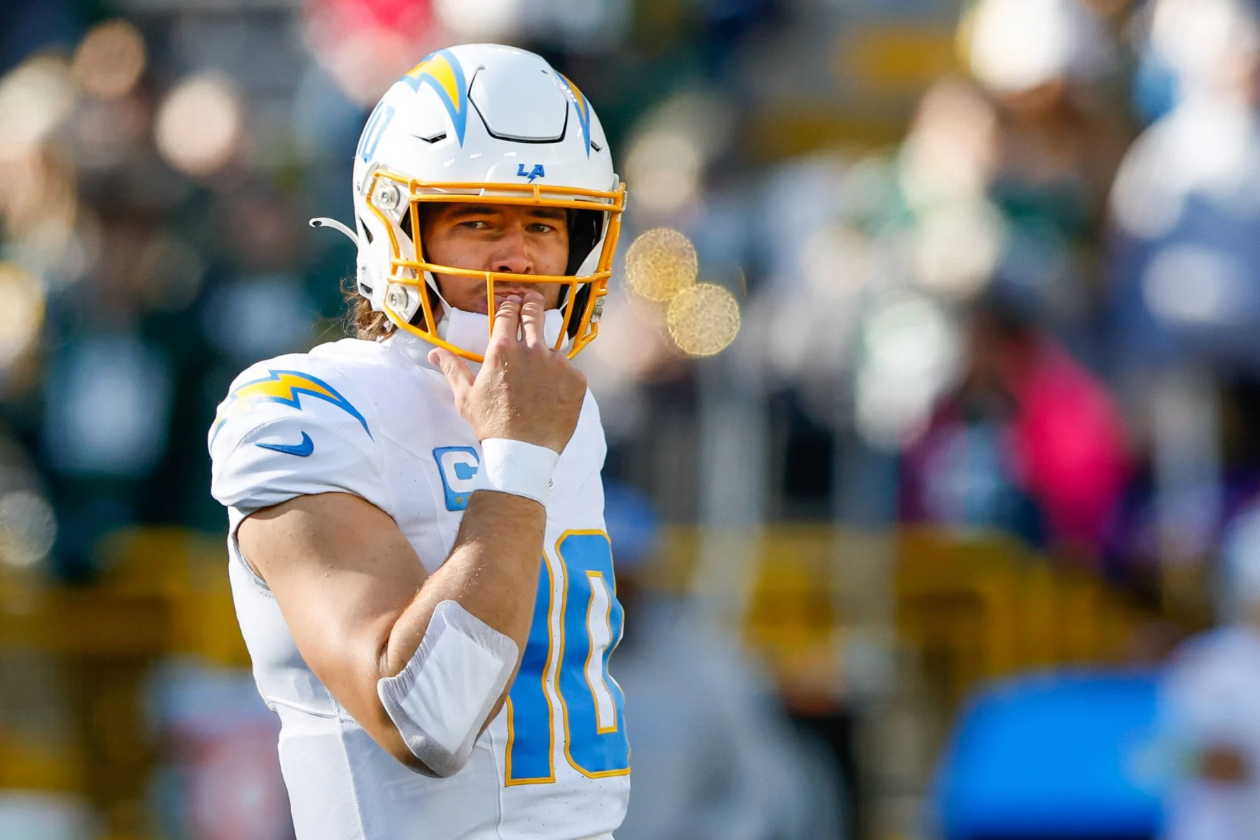 FootballR - NFL - Justin Herbert, ein NFL-Spieler, mit der Hand im Gesicht.