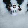 FootballR - NFL - Austin Jackson, ein Spieler der Miami Dolphins, steht vor Rauch.