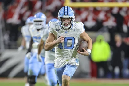 FootballR - NFL - Drake Maye, ein Quarterback im NFL Draft, läuft mit dem Ball.
