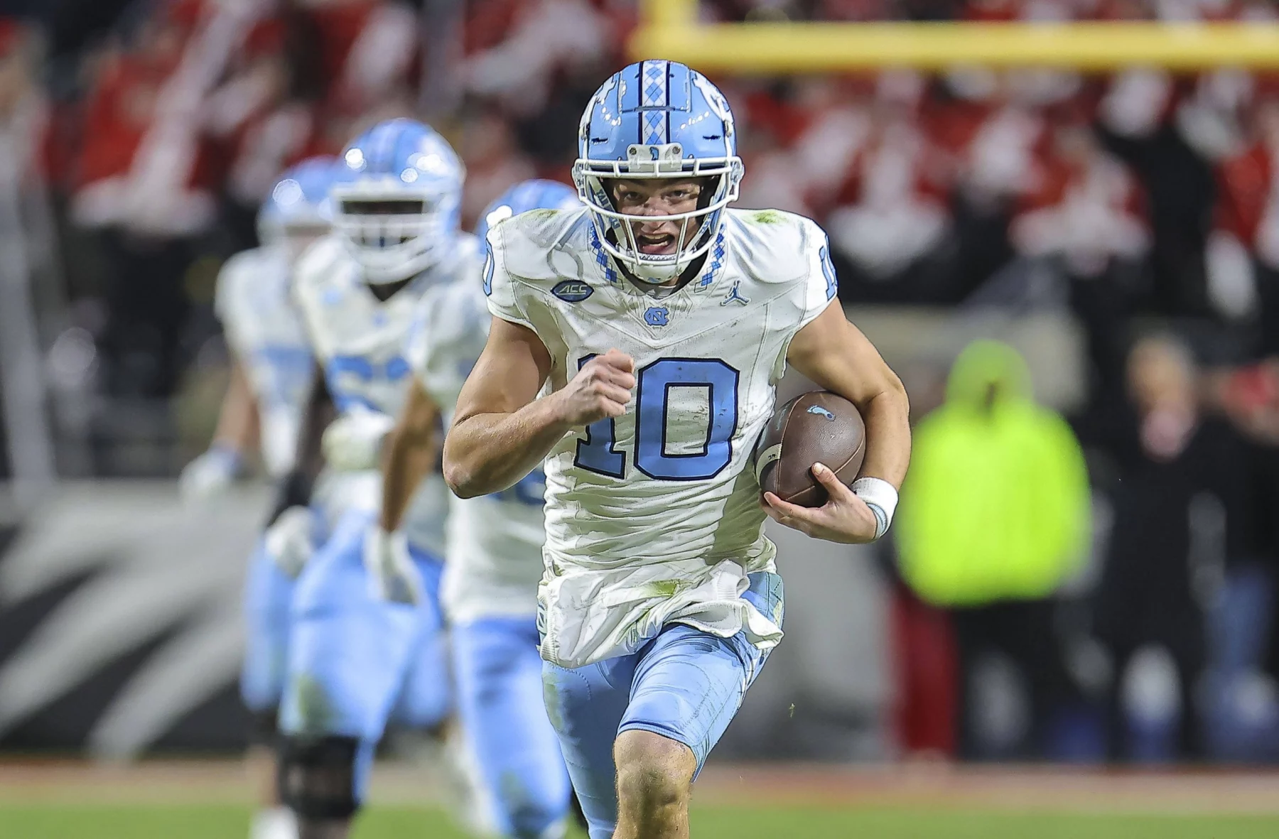 FootballR - NFL - Drake Maye, ein Quarterback im NFL Draft, läuft mit dem Ball.
