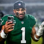 FootballR - Regeländerungen - NFL Spielverschiebung - Ein Spieler der Philadelphia Eagles, Jalen Hurts, macht während eines NFL-Spiels gegen die Seahawks ein Selfie im Regen.