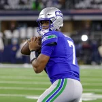 FootballR - NFL - Ein Footballspieler der Seahawks, Geno Smith, ist dabei, einen Ball zu werfen.