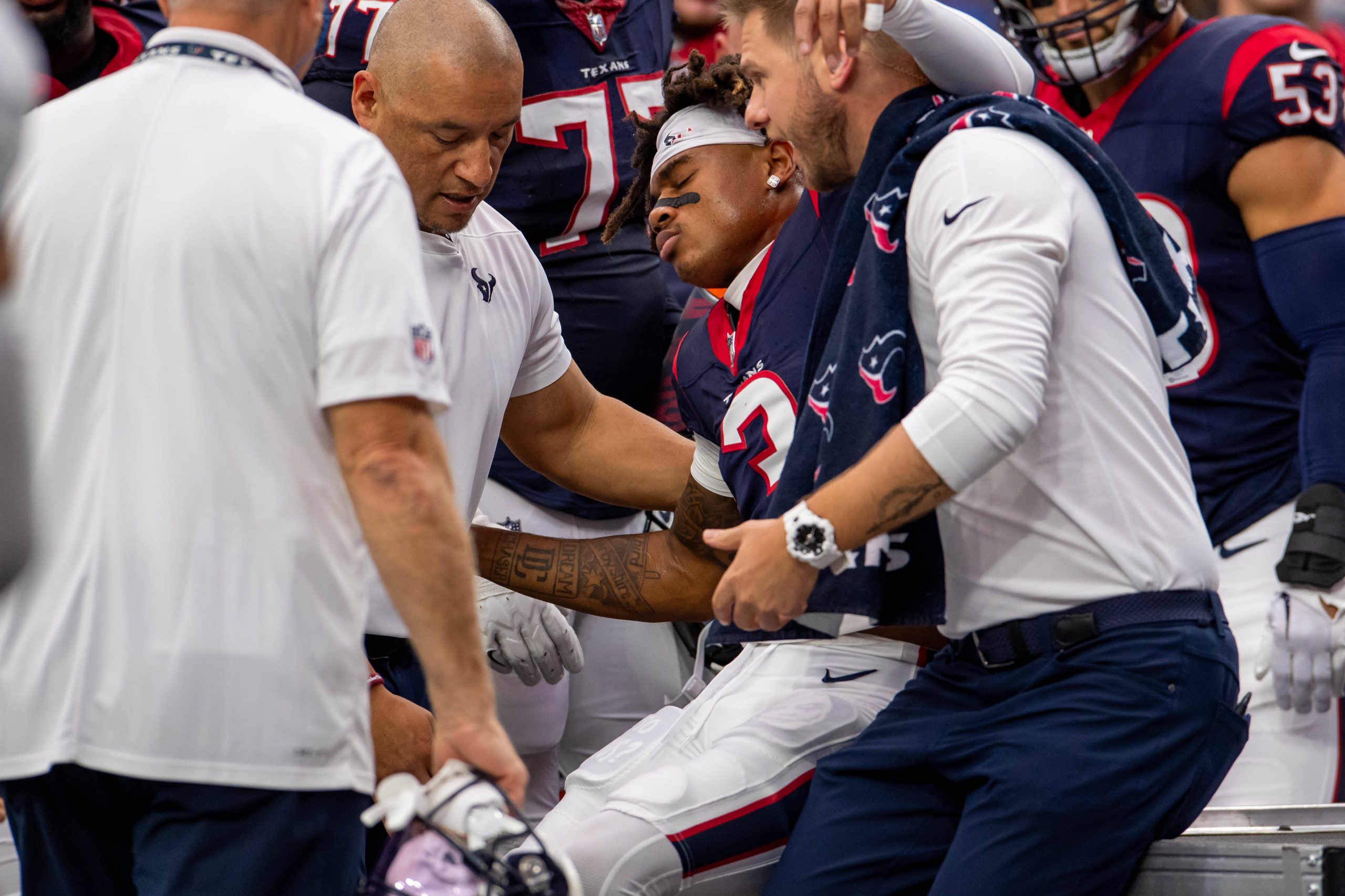 FootballR - NFL - Tank Dell - Einem Spieler der Houston Texans wird vom Feld geholfen, nachdem er einen schweren Rückschlag, insbesondere einen Wadenbeinbruch, erlitten hat.