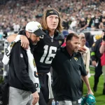 FootballR - NFL - Trevor Lawrence, ein Spieler der Jacksonville Jaguars, wird vom Spielfeld getragen.