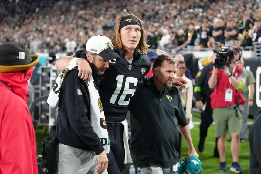 FootballR - NFL - Trevor Lawrence, ein Spieler der Jacksonville Jaguars, wird vom Spielfeld getragen.