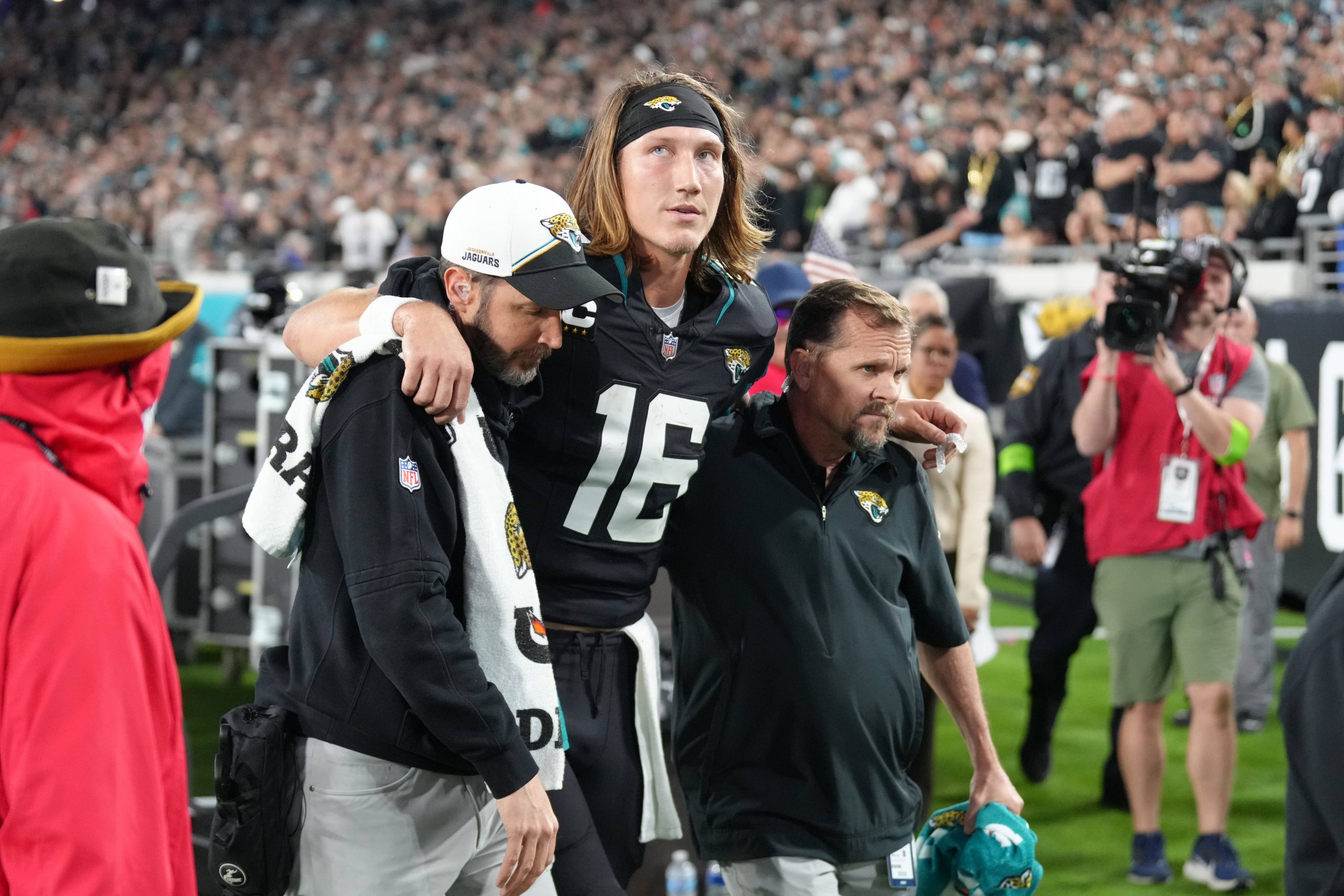 FootballR - NFL - Trevor Lawrence, ein Spieler der Jacksonville Jaguars, wird vom Spielfeld getragen.