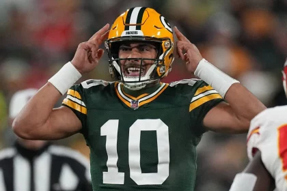 FootballR - NFL Quarterbacks - Ein Spieler der Green Bay Packers, Quarterback Jordan Love, hält während eines Spiels, möglicherweise in den Playoffs, die Hände hoch.