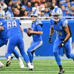 FootballR - NFL - Die Lions, angeführt von Jared Goff, laufen während eines Spiels gegen die Broncos mit dem Ball.