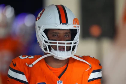 FootballR - NFL - Ein Spieler der Denver Broncos, Russell Wilson, der eine orange-weiße Uniform trägt.