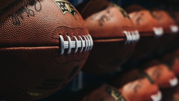FootballR - NFL - Eine Reihe von NFL-Fußbällen an der Wand, die den NFL Spielplan 2024 für die kommende Saison zeigen.