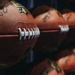 FootballR - NFL Spielplan 2025 - Eine Reihe von NFL-Fußbällen an der Wand, die den NFL Spielplan 2024 für die kommende Saison zeigen. NFL Schedule 2024