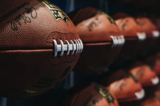FootballR - NFL Spielplan 2025 - Eine Reihe von NFL-Fußbällen an der Wand, die den NFL Spielplan 2024 für die kommende Saison zeigen. NFL Schedule 2024