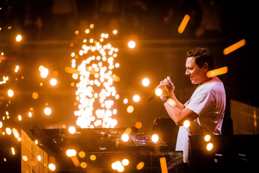 FootballR - NFL - Diese Beschreibung wurde automatisch generiert. DJ Tiësto mit einem Mikrofon auf der Bühne während des Super Bowl LVIII.