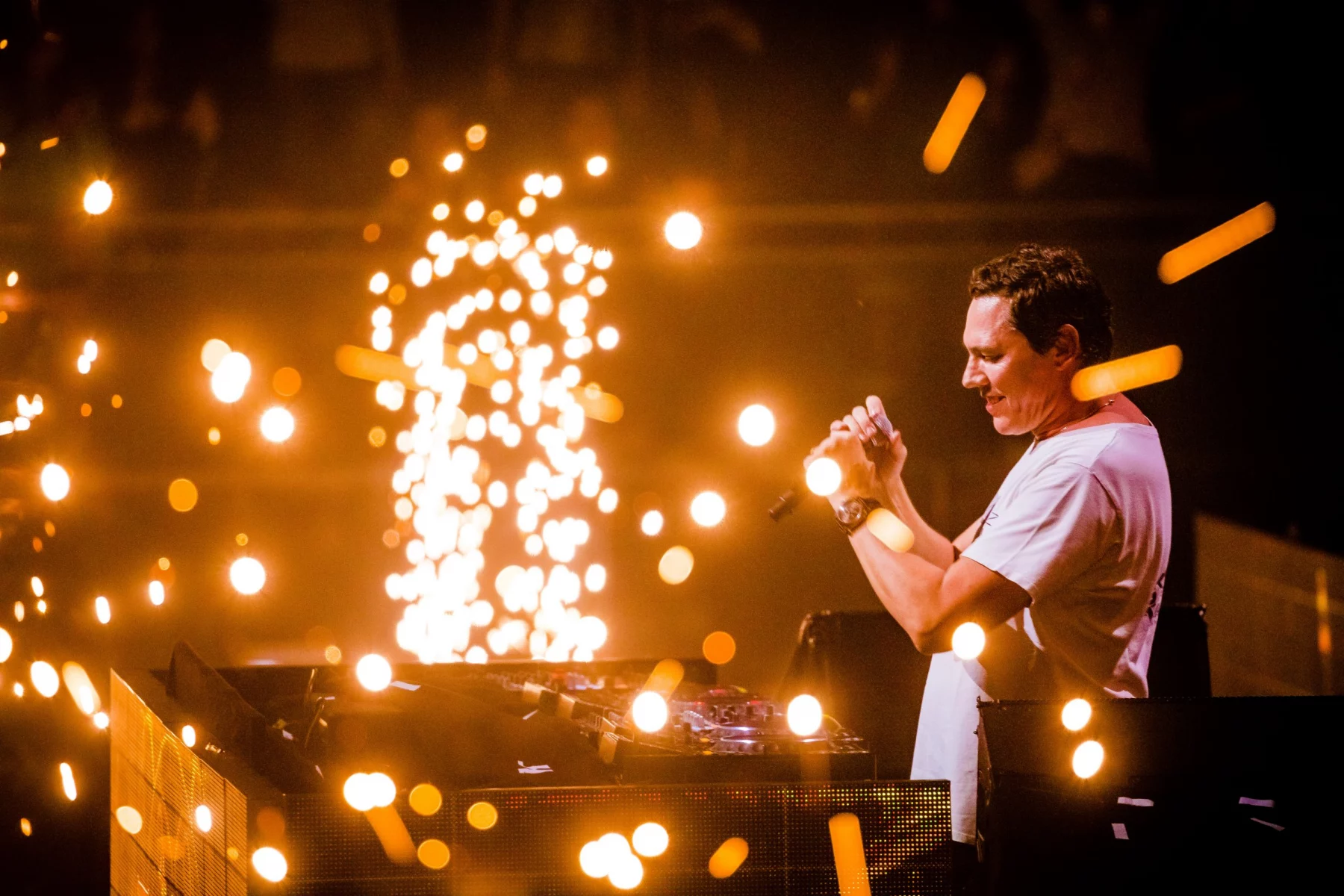 FootballR - NFL - Diese Beschreibung wurde automatisch generiert. DJ Tiësto mit einem Mikrofon auf der Bühne während des Super Bowl LVIII.