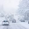 FootballR - NFL - Während eines Wintersturm in Buffalo fahren Autos eine schneebedeckte Straße entlang.