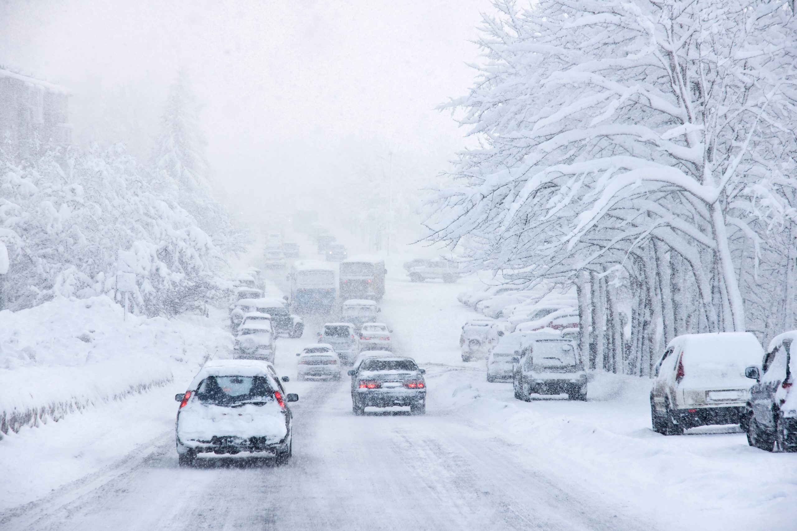 FootballR - NFL - Während eines Wintersturm in Buffalo fahren Autos eine schneebedeckte Straße entlang.