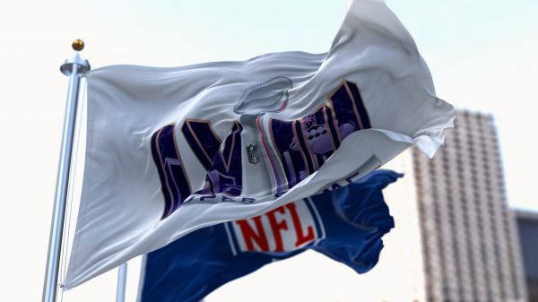 FootballR - NFL Playoffs - Die NFL-Flagge weht vor einem Gebäude und signalisiert die Spannung des Super Bowl LVIII.