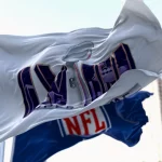 FootballR - NFL Playoffs - Die NFL-Flagge weht vor einem Gebäude und signalisiert die Spannung des Super Bowl LVIII.