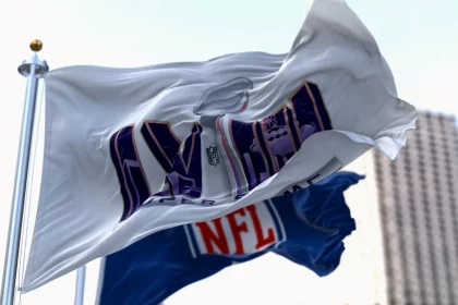 FootballR - NFL Playoffs - Die NFL-Flagge weht vor einem Gebäude und signalisiert die Spannung des Super Bowl LVIII.