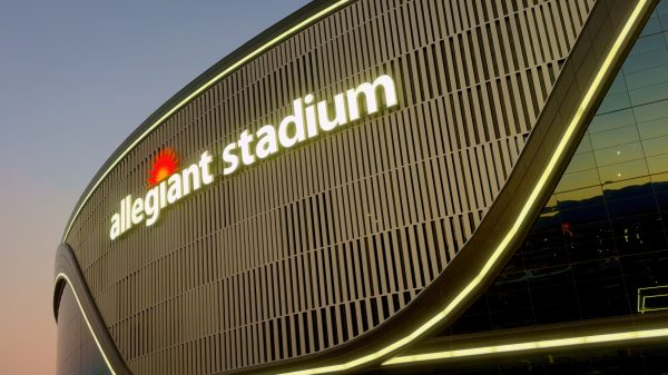 FootballR - NFL - Diese Beschreibung wurde automatisch generiert. Ein großes Gebäude mit den Buchstaben Allegiant Stadium und einem Raiders-Anlage-Logo darauf.