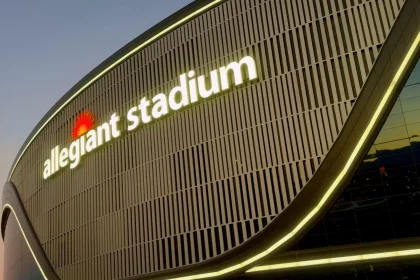 Chip Kelly - NFL - Aidan O'Connell Diese Beschreibung wurde automatisch generiert. Ein großes Gebäude mit den Buchstaben Allegiant Stadium und einem Raiders-Anlage-Logo darauf.