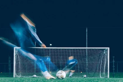 FootballR - NFL - Ein Fußballspieler kickt nachts den Ball.