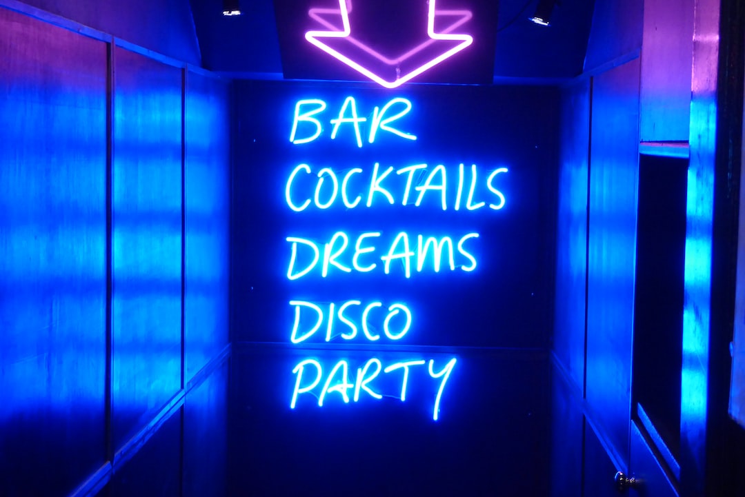 FootballR - NFL - Eine Leuchtreklame mit der Aufschrift „Bar, Cocktails, Träume, Disco-Party“.