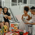 FootballR - NFL - Eine Familie sitzt auf einer Veranda und isst Essen.