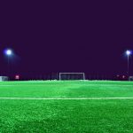 FootballR - NFL - Ein Fußballplatz wurde nachts beleuchtet.