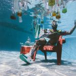 FootballR - NFL - Ein Mann sitzt mit Flaschen auf einem Stuhl unter Wasser.