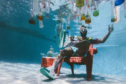 FootballR - NFL - Ein Mann sitzt mit Flaschen auf einem Stuhl unter Wasser.