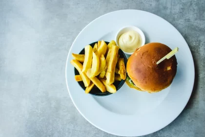 FootballR - NFL - Ein Burger und Pommes frites auf einem weißen Teller.