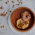 FootballR - NFL - Ein Donut mit Sesamkörnern und Nüssen auf einer Zeitung.