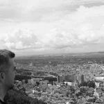 FootballR - NFL - Diese Beschreibung wurde automatisch generiert. Schwarz-Weiß-Foto eines Mannes mit Blick auf eine Stadt.